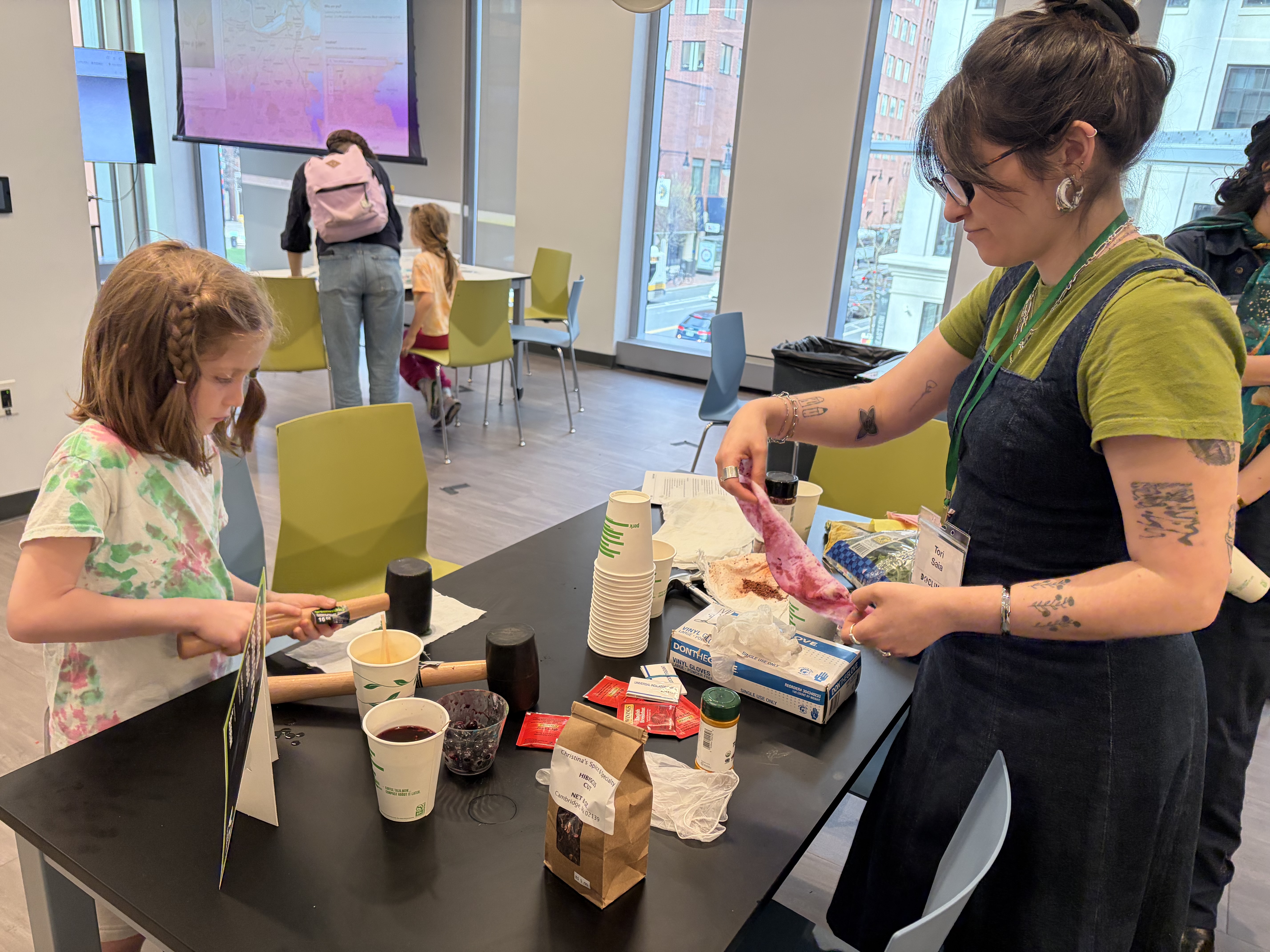 A young girl and a program leader use dyes created by natural products. 