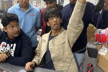 Members from both the software and hardware teams are shown working on creating a solution to a technical issue.