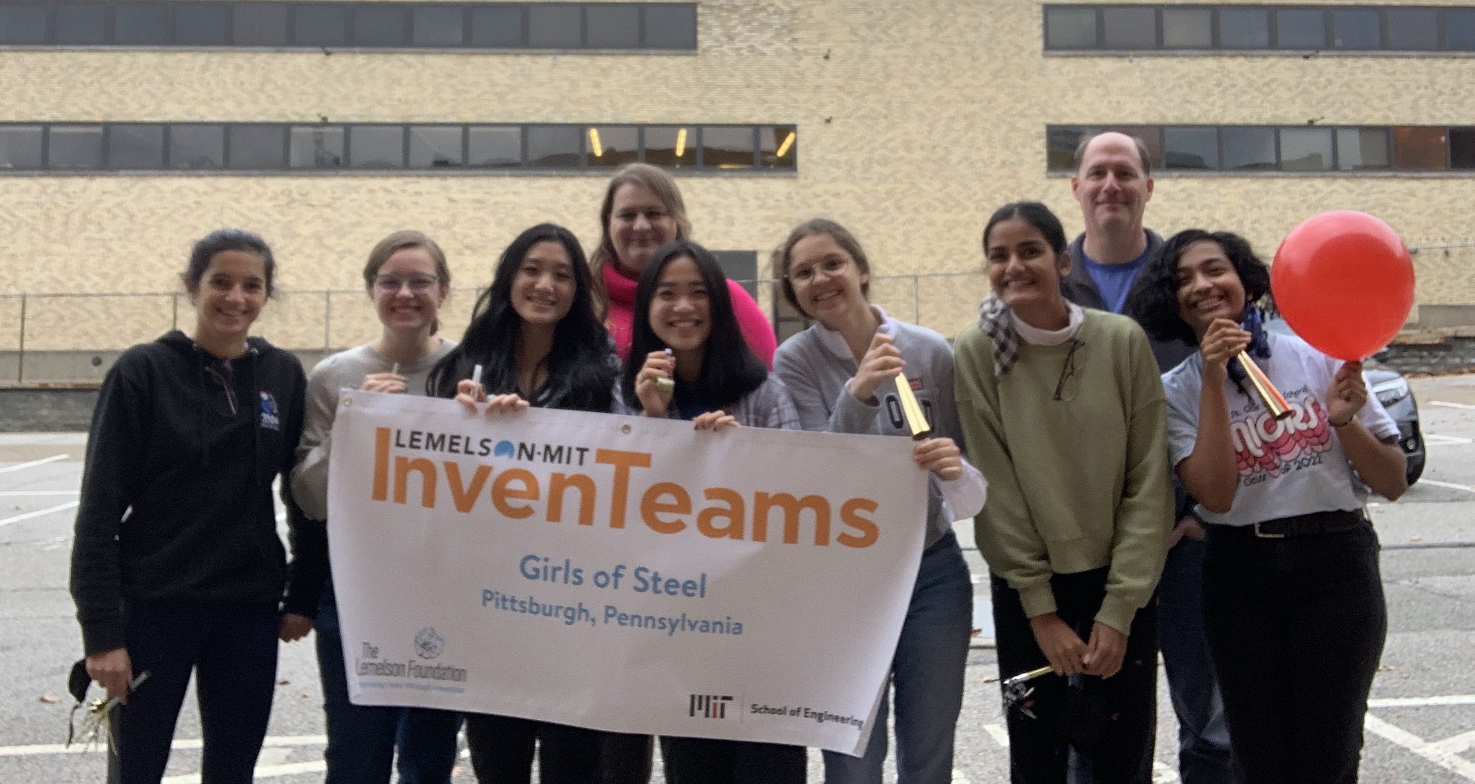 Girls of Steel Team with banner